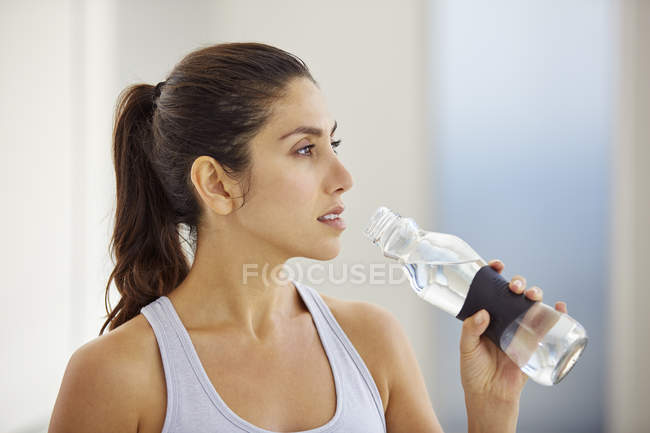 Женщина после тренировки питьевой воды — стоковое фото
