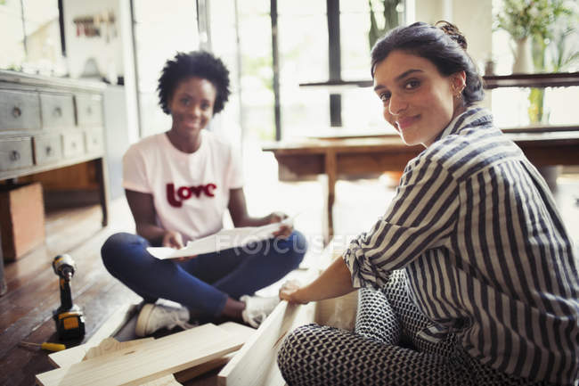 Portrait smiling, confident women with instructions assembling furniture — Stock Photo