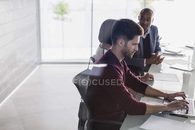 Businessman working at laptop in conference room meeting — Stock Photo