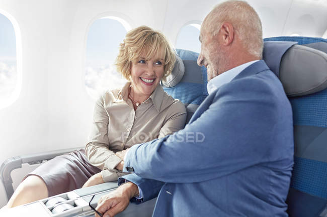 Cariñosa pareja madura cogida de la mano en el avión - foto de stock