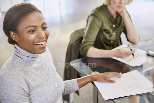 Smiling businesswoman with paperwork in meeting — Stock Photo