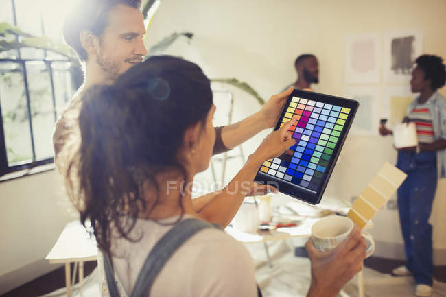 Amici con tablet digitale visualizzazione digitale campioni di vernice, pittura soggiorno — Foto stock