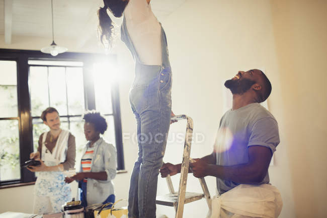 Friends painting living room — Stock Photo