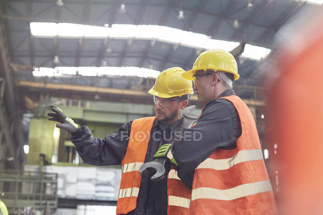 Männliche Arbeiter reden in Fabrik — Stockfoto