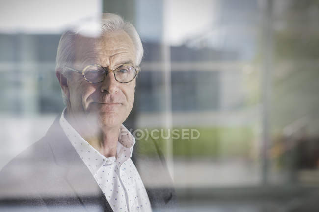 Портрет улыбающийся старший бизнесмен у окна — стоковое фото