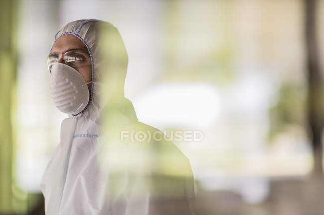 Pensive scientist in clean suit looking away — Stock Photo