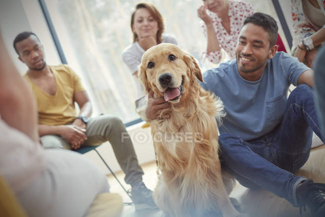 Чоловік пестить собаку в груповій терапії сеанс — стокове фото