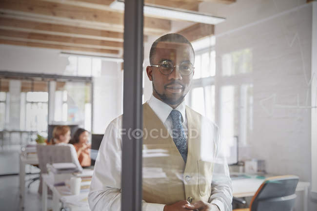 Porträt selbstbewusster Geschäftsmann am Fenster im Büro — Stockfoto