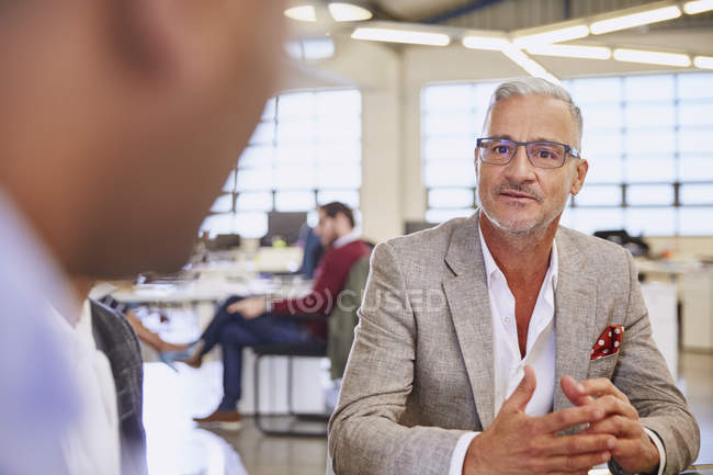 Бизнесмены разговаривают на встрече в современном офисе — стоковое фото