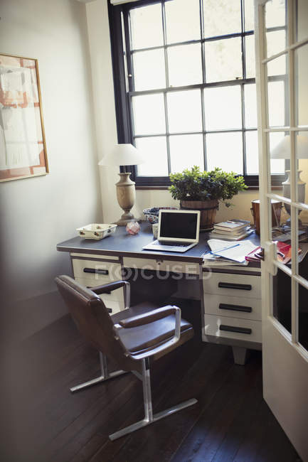 Laptop and paperwork on desk in home office — Stock Photo