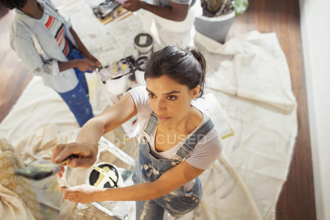 Jovem mulher pintando sala de estar — Fotografia de Stock