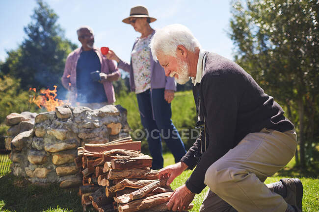 Uomo anziano attivo accatastamento legna da ardere — Foto stock