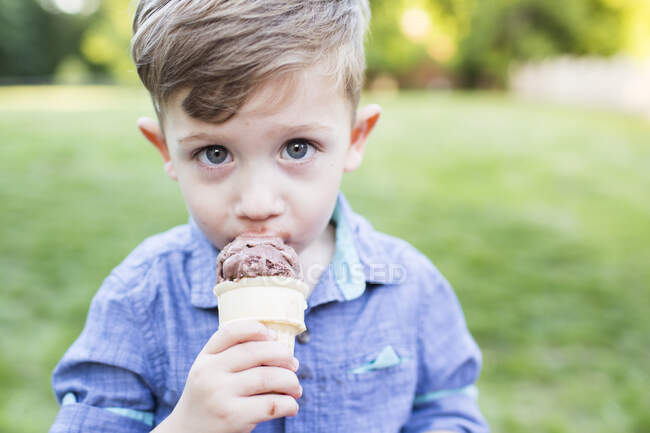 Retrato lindo preescolar chico comer helado cono - foto de stock