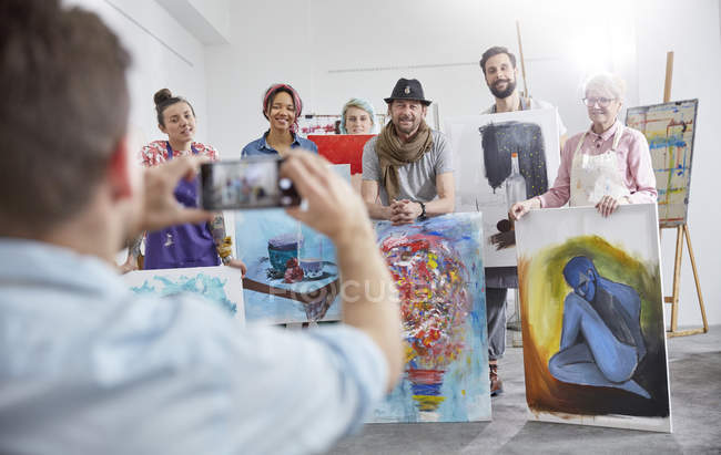 Homem fotografando colegas de classe de arte no estúdio de arte — Fotografia de Stock