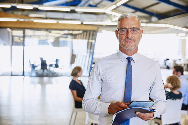 Портрет впевнений бізнесмен з цифровим планшетом в офісі — стокове фото