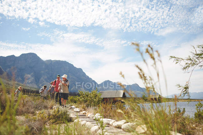 Amici escursioni a piedi lungo il soleggiato lago estivo — Foto stock