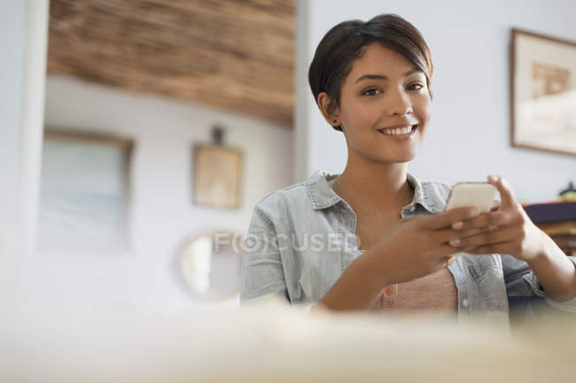 Porträt lächelnde junge Frau mit Handy — Stockfoto