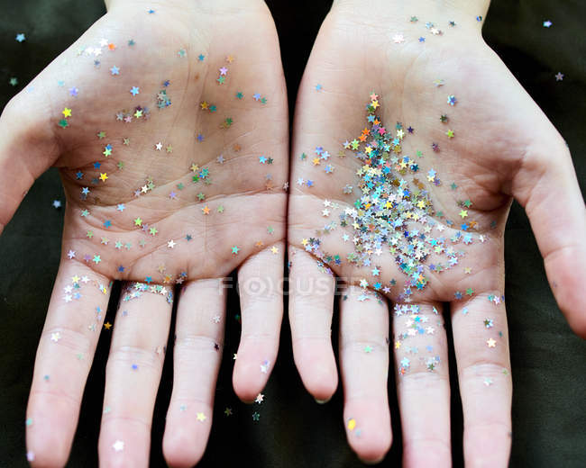 Glitter di coriandoli di stella su mani — Foto stock