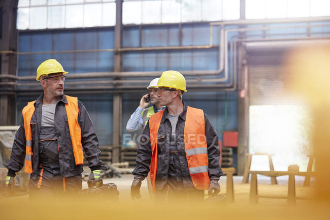 Male workers walking in factory — Stock Photo