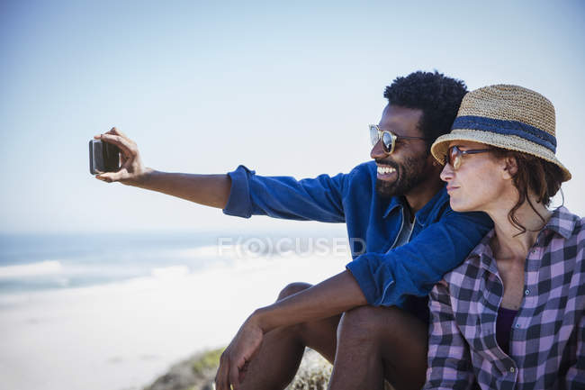 Multiethnisches Paar macht Selfie am sonnigen Sommerstrand — Stockfoto