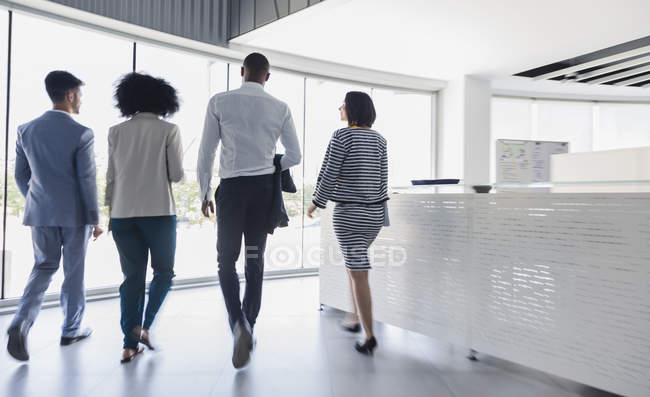 Business people walking in office lobby — Stock Photo