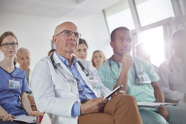 Cirurgiões atentos, médicos e enfermeiros ouvindo em conferência — Fotografia de Stock