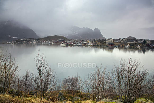 Pueblo pesquero a orillas del lago tranquilo, Reine, Lofoten, Noruega - foto de stock