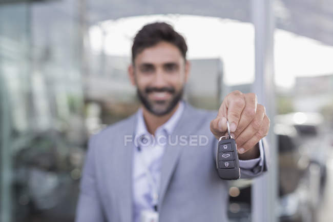 Retrato sorrindo, vendedor de carros confiante segurando, mostrando novas chaves do carro — Fotografia de Stock