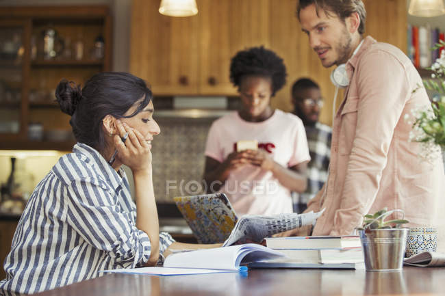 Friend roommates working and reading newspaper at dining room table — Stock Photo