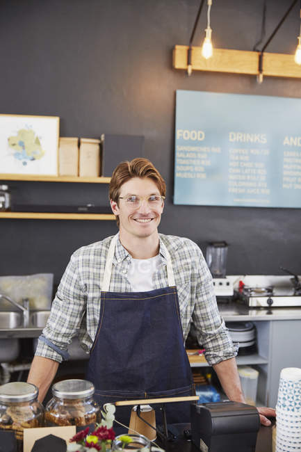 Portrait confident cafe owner at cash register — Stock Photo