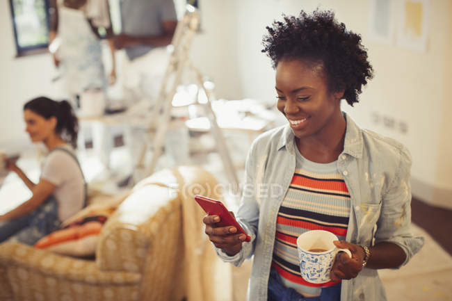 Mujer bebiendo café y mensajes de texto con teléfono inteligente - foto de stock