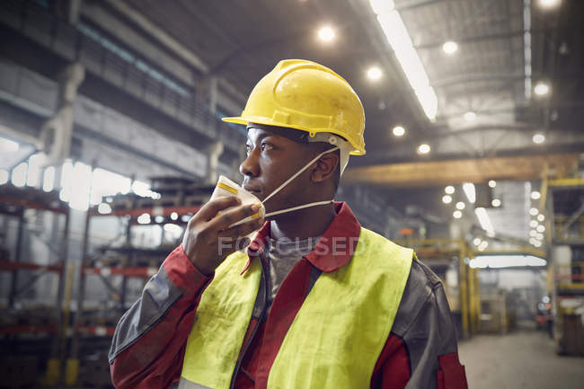 Steelworker removing protective mask in steel mill — Stock Photo