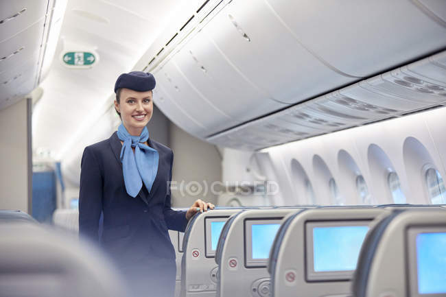 Retrato sorridente, confiante mulher comissária de bordo no avião — Fotografia de Stock