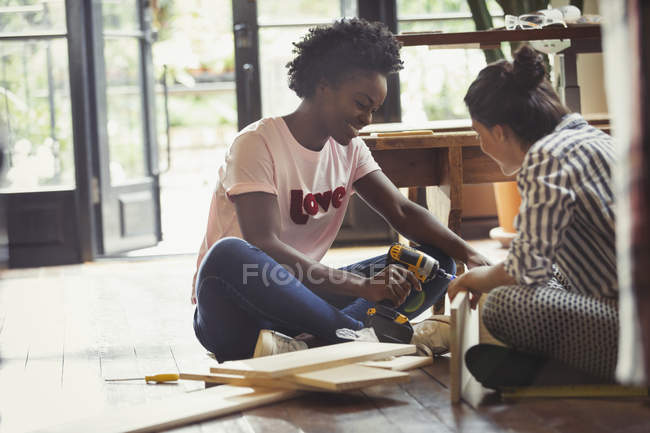 Жінки збирають меблі з силовим дрилем — стокове фото