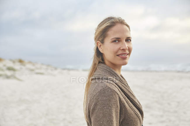 Retrato sorrindo mulher loira na praia de inverno — Fotografia de Stock