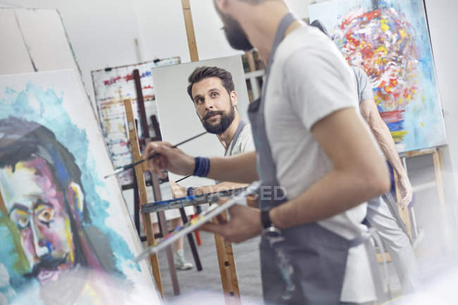 Artistas masculinos pintando en estudio de clase de arte - foto de stock