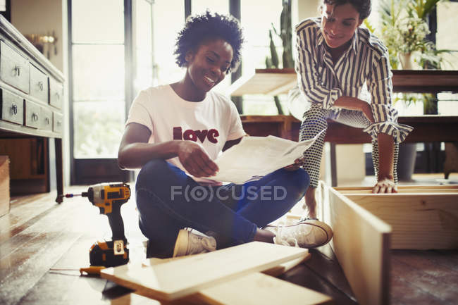 Women assembling furniture at home — Stock Photo