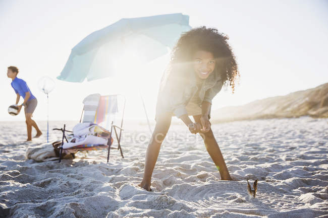 Retrato juguetona chica jugando en la soleada playa de verano - foto de stock