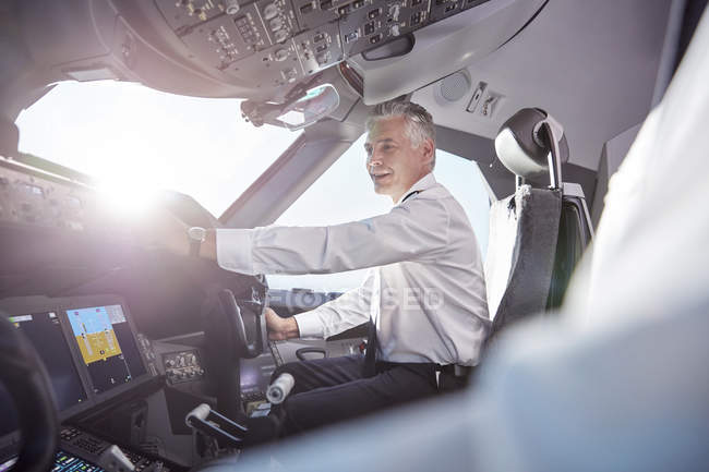 Piloto masculino sorridente no cockpit do avião — Fotografia de Stock