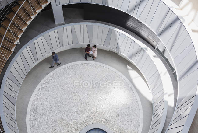 Vista desde arriba de gente de negocios hablando en el patio del atrio de la oficina arquitectónica, moderna — Stock Photo