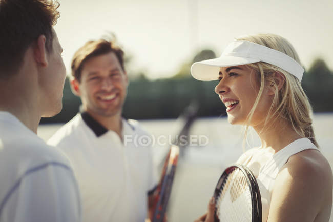 Male and female tennis players talking on tennis court — Stock Photo