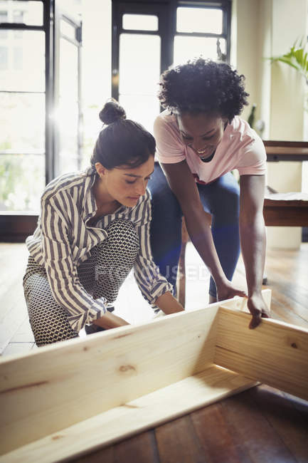 Women assembling furniture indoors — Stock Photo