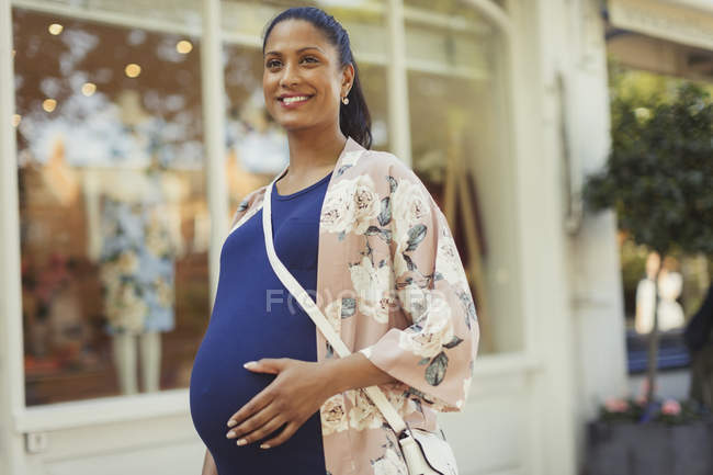 Portrait smiling pregnant woman outside storefront — Stock Photo