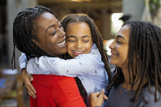 Madre e hijas cariñosas abrazándose - foto de stock