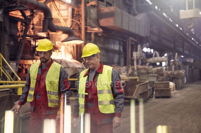 Steelworkers walking in steel mill together — Stock Photo