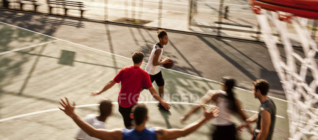 Мужчины играют в баскетбол на площадке — стоковое фото