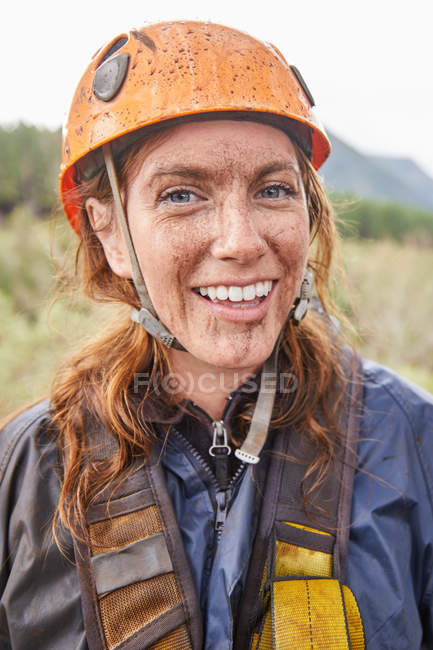 Portrait smiling, muddy woman zip lining — Stock Photo