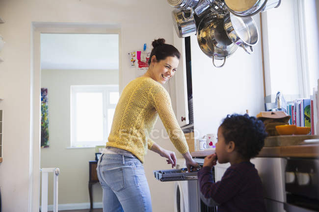 Happy caucasian mother with african american son at kitchen — Stock Photo