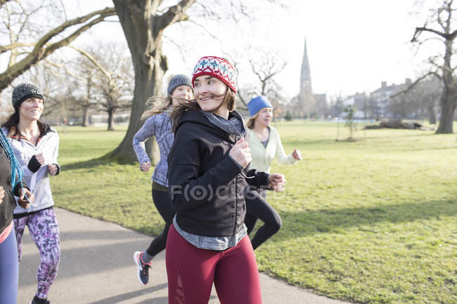 Впевнена жінка біжить в сонячному парку — стокове фото