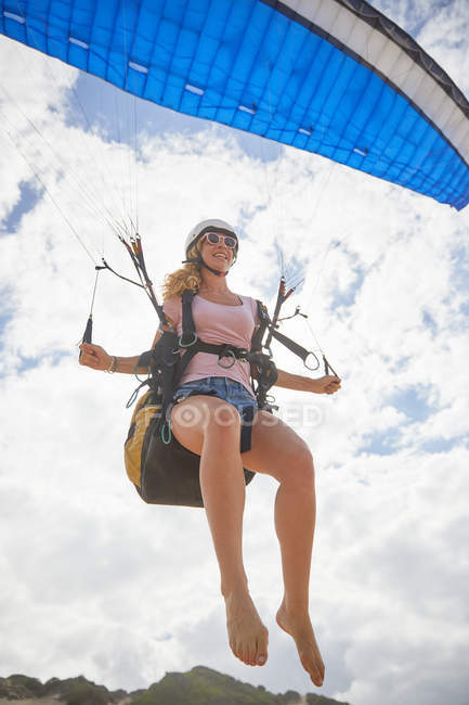 Smiling female paraglider mid-air — Stock Photo